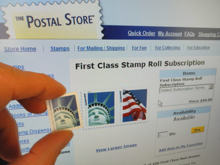 A first class 44-cent US stamp is held u
